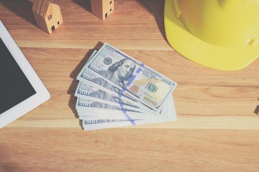 Engineer sitting and counting dollar bills photo