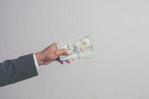 closeup businessman in suit holding one hundred 100 dollar bill. money concept photo