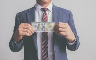 closeup businessman in suit holding one hundred 100 dollar bill. money concept photo