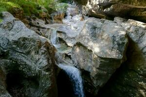 a waterfall flowing through a rocky canyon photo