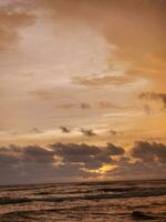 Beautiful wide shot of an ocean during dawn with pink skies photo