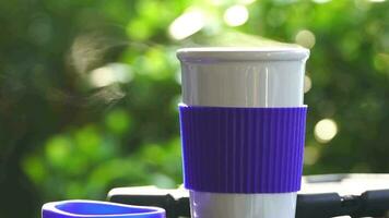 lent mouvement. chaud céramique blanc café tasse avec fumée mis à l'extérieur le voiture tableau de bord à lever du soleil dans le matin, dans une Naturel Contexte. chaud café boisson concept, sélectif se concentrer, doux se concentrer. video