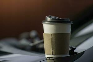 Paper coffee cups placed outside the car dashboard at sunrise in the morning,  selective focus, soft focus. photo