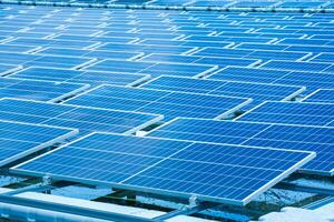 Side view of solar panels floating on water in a lake, for generating electricity from sunlight, selective focus, soft focus. photo