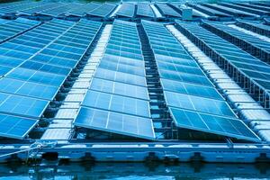 Side view of solar panels floating on water in a lake, for generating electricity from sunlight, selective focus, soft focus. photo