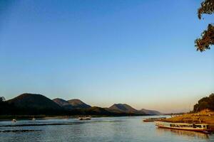 boats on the river with mountains in the background photo