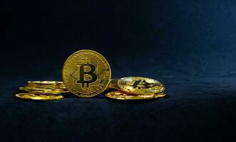 Golden bitcoin in the middle of pile, Bitcoin on dark blue background, Background with ray of light. photo