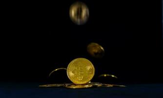 dorado bitcoin en montón, bitcoin que cae con negro antecedentes. foto