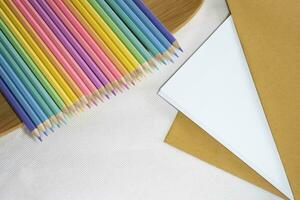 parte superior izquierda vista, grupo de color lápiz tendido en fila recto línea en chapa en blanco y papel fondo, Copiar espacio. foto