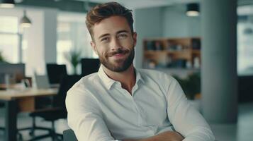 Confident professional man at office desk, smiling into the camera, bathed in daylight photo