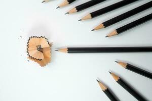 Black pencil and pencil shavings surround by group of black pencil with white background, School concept, Painting and education concepts. photo