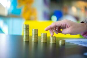 Business woman touching pile of coins on black desk, Business for future concept. photo