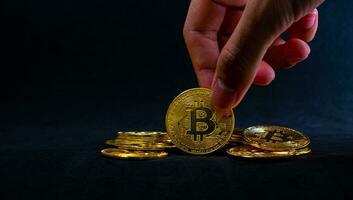 Close up of Hand hold golden bitcoin, Bitcoin  with Black background. Online shopping and Crypto currency concept. photo