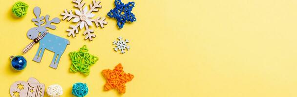 Top view of yellow background with New Year toys and decorations. Christmas time Banner concept with copy space photo