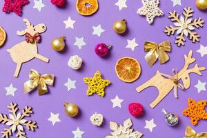 Top view of New Year toys and decorations on purple background. Christmas time concept photo