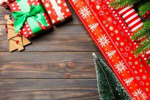 Top view of Christmas background made of fir tree, rolled wrapping paper and other decorations on wooden background. New year holiday concept with copy space photo