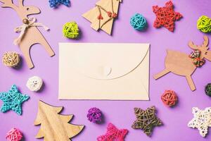 Top view of craft envelope. New Year decorations on purple background. Festive stars and balls. Merry Christmas concept photo