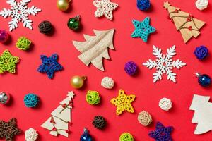 Top view of holiday decorations and toys on red background. Christmas ornament concept photo