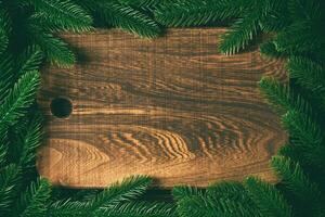 Top view of wooden plate decorated with fir tree branches. New Year dinner concept with empty space for your design photo