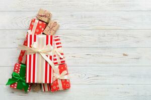 Christmas tree made of beautifuly wrapped presents on colored background, view from above. New Year gift box minimal concept with copy space photo