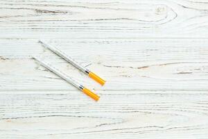 Top view of insulin syringe prepared for injection at wooden background. Diabetes concept with copy space photo