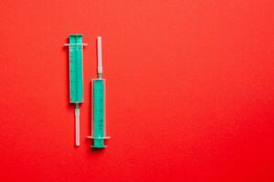 Top view of syringes in a row for medical injection on colorful background with copy space. Health and vaccination concept photo