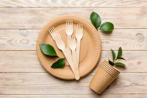 set of empty reusable disposable eco-friendly plates, cups, utensils on light white colored table background. top view. Biodegradable craft dishes. Recycling concept. Close-up photo