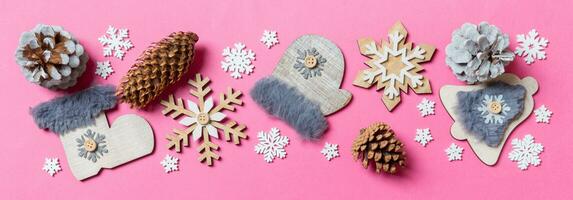 Top view of holiday toys and decorations on pink Christmas background. Banner New Year time concept with copy space photo