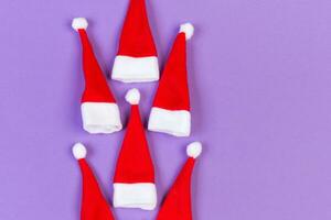 Top view od stylish red Santa hats on colorful background. Merry Christmas concept with copy space photo
