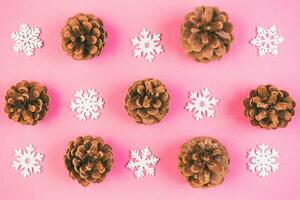 Top view of holiday composition made of pine cones and white snowflakes on colorful background. Winter time and Christmas concept with copy space photo