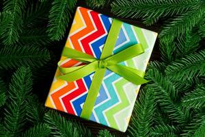 Top view of holiday gift box and fir tree branches with empty space for your design. New year ornament concept photo