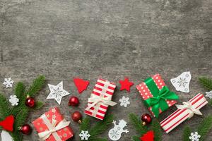 Christmas decorations and fir tree branch and gift boxon dark table. Top view frame with copy space photo