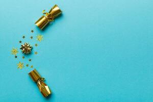 Christmas crackers with shiny confetti on color background, top view, copy space photo