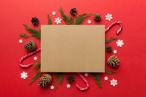 Flat lay Christmas composition. square Paper blank, pine tree branches, christmas decorations on Colored background. Top view, copy space for text photo