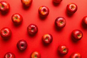 Many red apples on colored background, top view. Autumn pattern with fresh apple above view photo