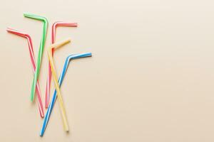 Drinking straws for party on Colored background. Top view of colorful plastic disposable straws for summer cocktails. different straws for juice with copy space photo