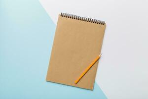 school brown notebook on a colored background, spiral craft notepad on a table Top view photo