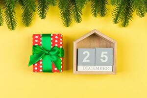 Top view of fir tree, wooden calendar and gift box on colorful background. The twenty fifth of December. Merry Christmas time with empty space for your design photo
