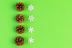 Top view of New Year ornament made of white snowflakes and pine cones on colorful background. Winter holiday concept with empty space for your design photo