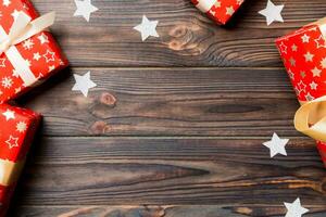 Top view of Christmas background made of gift boxes and snowflakes on wooden background. New year holiday concept with copy space photo