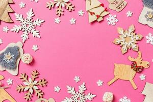 vista superior de decoraciones navideñas y juguetes sobre fondo rosa. concepto de adorno navideño con espacio vacío para su diseño foto
