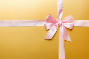 Top view of purple ribbon rolled and pink bow isolated on colored background. Flat lay with copy space photo