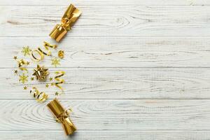 Christmas crackers with shiny confetti on color background, top view, copy space photo