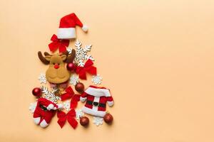 Christmas tree made from colored suit santa decoration on colored background, view from above. New Year minimal concept with copy space photo