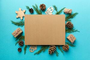 Flat lay Christmas composition. square Paper blank, pine tree branches, christmas decorations on Colored background. Top view, copy space for text photo