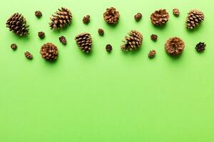 Christmas pine cones on colored paper border composition. Christmas, New Year, winter concept. Flat lay, top view, copy space photo