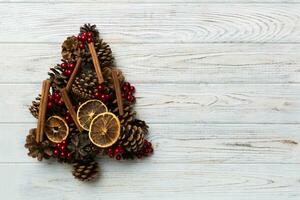 Christmas tree made from natural cones on colored background, view from above. New Year minimal concept with copy space photo