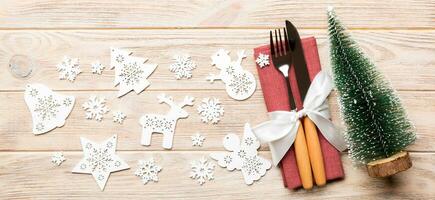 Top view Banner of fork and knife tied up with ribbon on napkin on wooden background. Christmas decorations and New Year tree. Happy holiday concept with empty space for your design photo