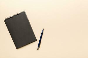 school notebook on a colored background, spiral black notepad on a table Top view photo