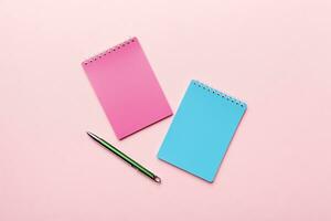 two school colored notebook on a desk background, spiral craft notepad on a table Top view photo